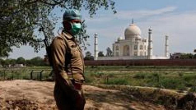 A policeman wearing a protective mask stands guard near the Taj Mahal amid the coronavirus pandemic in Uttar Pradesh’s Agra.(REUTERS PHOTO.)