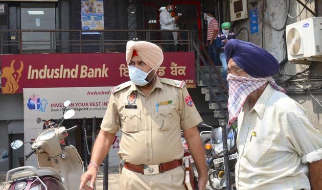 Police with the victim, Kuljit Singh, outside the IndusInd branch on Gill Road in Ludhiana on Tuesday. (Gurpreet Singh/HT) Police with the victim, Kuljit Singh, outside the IndusInd branch on Gill Road in Ludhiana on Tuesday. (Gurpreet Singh/HT)