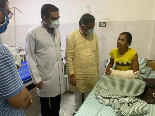 Kusum Kumari, 15, interacting with Jalandhar BJP leader Manoranjan Kalia while undergoing treatment at a local hospital. She took on two snatchers who tried to flee with her new smartphone that her father had bought on instalments for her to attend online classes.(HT Photo)