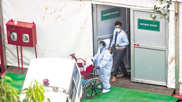 Health official attending to a patient at the jumbo Covid care facility at COEP ground in Pune on September 2. From shortage of doctors and inadequate equipment to lack of coordination, the newly set up facility has invited wrath from patients and their relatives.(PRATHAM GOKHALE/HT)
