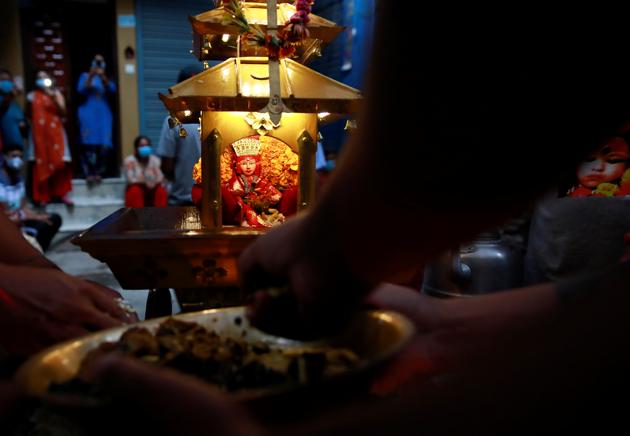 People offer prayers to the idol of Living Goddess Kumari kept inside the miniature chariot during the annual festival of Indra Jatra as the official celebration has been cancelled due to the spread of the coronavirus disease (COVID-19) in Kathmandu, Nepal September 2, 2020. (REUTERS) People offer prayers to the idol of Living Goddess Kumari kept inside the miniature chariot during the annual festival of Indra Jatra as the official celebration has been cancelled due to the spread of the coronavirus disease (COVID-19) in Kathmandu, Nepal September 2, 2020. (REUTERS)