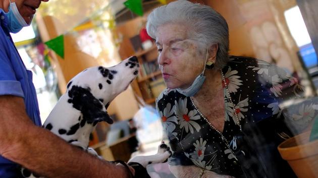 Maria de Concepcion Illa, 89, who lives in a care home, blows a kiss to Menta, the dog of her neighbour Antoni. (REUTERS) Maria de Concepcion Illa, 89, who lives in a care home, blows a kiss to Menta, the dog of her neighbour Antoni. (REUTERS)