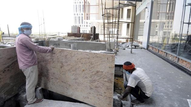 Workers seen at an under construction site during lockdown, at at Supertech Supernova, Sector 94, in Noida.(Sunil Ghosh / Hindustan Times)