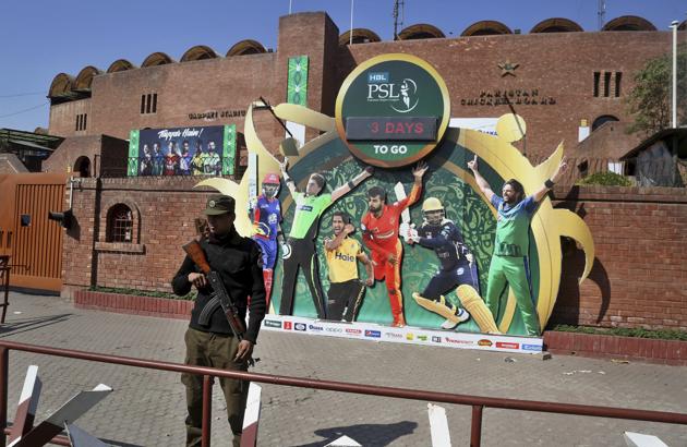 In this Monday, Feb. 17, 2020 photo, a police officer stands guard next to poster of cricket players displayed outside the Gaddafi stadium for upcoming Pakistan Super League, in Lahore, Pakistan.(AP) In this Monday, Feb. 17, 2020 photo, a police officer stands guard next to poster of cricket players displayed outside the Gaddafi stadium for upcoming Pakistan Super League, in Lahore, Pakistan.(AP)