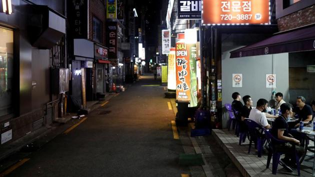 People drink outside in Seoul as tougher social distancing rules continue, South Korea. (REUTERS) People drink outside in Seoul as tougher social distancing rules continue, South Korea. (REUTERS)