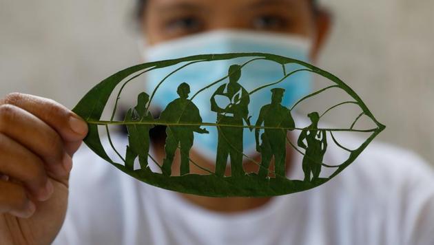 Filipino artist Mary Mae Dacanay shows one of her leaf artworks, a tribute to COVID-19 front liners, in her home in Binan, Laguna, Philippines, September 1, 2020.(REUTERS/Eloisa Lopez)