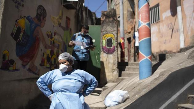 A city health worker takes a break during a Covid-19 testing program that aims to administer 20,000 tests in Rio de Janeiro's poorer neighbourhoods at Morro da Providencia favela on September 3. Brazil on September 3 crossed 4 million confirmed coronavirus cases, doubling its infection count in two months as large parts of the Latin American nation emerge from isolation. (Silvia Izquierdo / AP) A city health worker takes a break during a Covid-19 testing program that aims to administer 20,000 tests in Rio de Janeiro's poorer neighbourhoods at Morro da Providencia favela on September 3. Brazil on September 3 crossed 4 million confirmed coronavirus cases, doubling its infection count in two months as large parts of the Latin American nation emerge from isolation. (Silvia Izquierdo / AP)