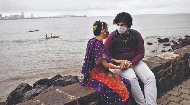 A masked couple sits by the Arabia Sea in Mumbai.(Sooni Taraporevala)