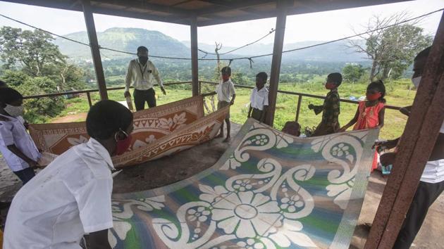 Children lay floor mats in a veranda ahead of a class at Kalamshet village in Pune on September 4. “Students should not miss out on classes amid the pandemic and all students have the right to education, be it the city or rural areas,” Sanjeev Bagul told the photographer. (Pratham Gokhale / HT Photo) 