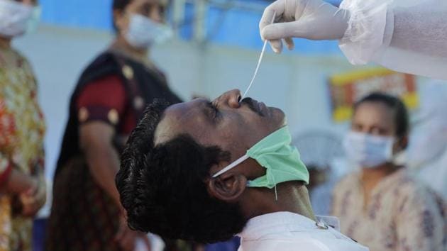 A health worker takes a nasal swab sample to test for Covid-19 at a check post erected to screen people coming from outside the city, in Ahmedabad, India.(AP)