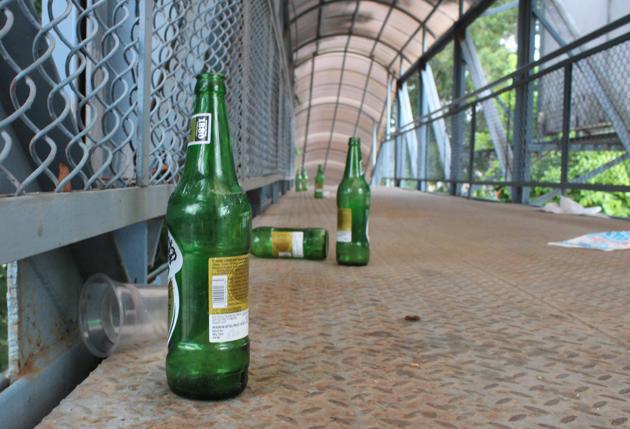Beer bottles, waste lie scattered on a foot overbridge in Mohali.(HT Photo)