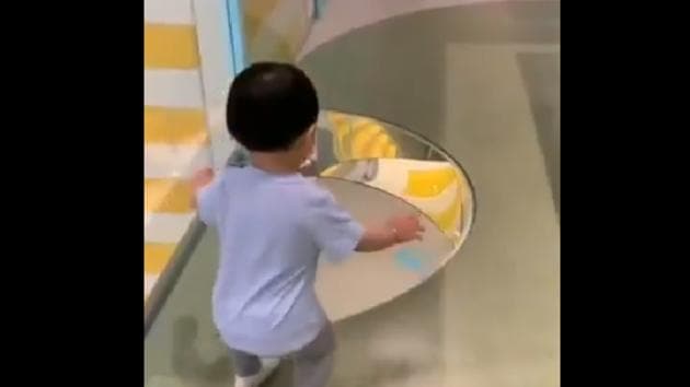 The image shows the kid stopping in front of the see-through floor.(Twitter/@RexChapman)