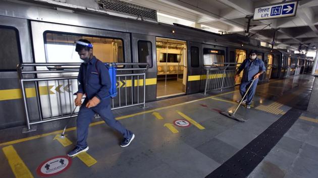 Metro workers sanitizing the HUDA City Centre Metro Station premises in Gurugram on September 7. Delhi chief minister Arvind Kejriwal, took to Twitter, expressing his happiness over the resumption of the Metro, adding there should be no negligence in following precautions against Covid-19. (Sanjeev Verma / HT Photo)