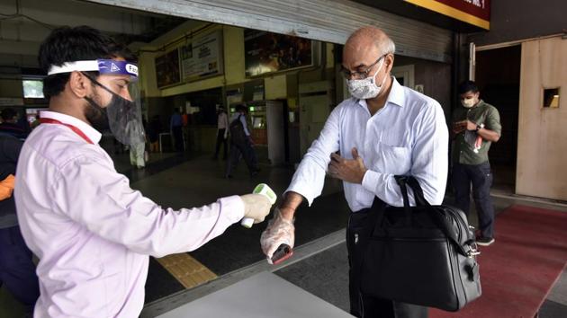 A traveller is thermal screened before being allowed to proceed to the station platform at HUDA City Centre Metro Station on September 7. Various steps, such as strict adherence to wearing masks and using sanitizers, social distancing, using smart cards only and thermal screening have been put in place by the DMRC to ensure safe commutes. (Sanjeev Verma / HT Photo)