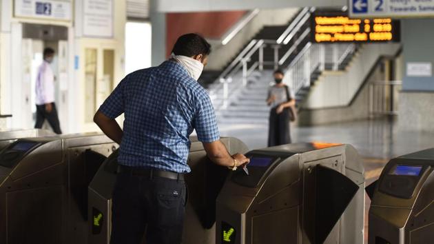 A man operates that the automated turnstiles at Chattarpur Metro Station in New Delhi on September 7. Tokens and all cash transactions have been barred from the metro travel experience at the moment considering they lead to items changing hands frequently. Only Smart Cards recharged electronically are allowed for now. (Sanjeev Verma / HT Photo)