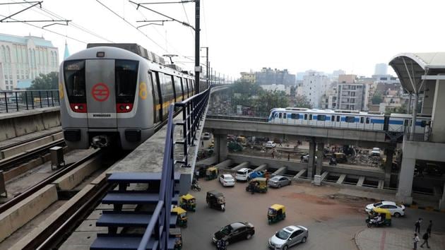 A Delhi Metro Rail Corp. train, left, travels past another train during the resumption of services in Gurugram, Haryana.(Bloomberg)