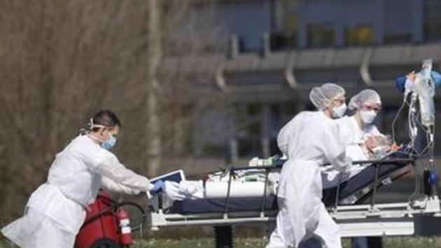 A victim of the Covid-19 coronavirus is evacuated by stretcher from the Mulhouse civil hospital in eastern France. (AP) A victim of the Covid-19 coronavirus is evacuated by stretcher from the Mulhouse civil hospital in eastern France. (AP)