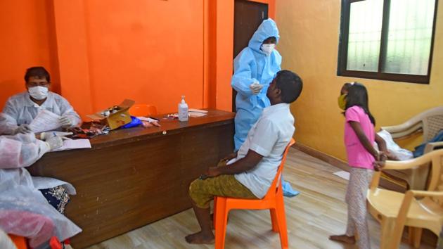 A health worker collects a swab sample from a resident of Patel Nagar at Santacruz (East) in Mumbai on September 7. The Maharashtra government has, in its fourth revision, slashed the RT-PCR rates to bring them down to ₹1,200-₹2,000, from the earlier rates ranging between ₹1,900 and ₹2,500, HT reported. (Vijayanand Gupta / HT Photo)