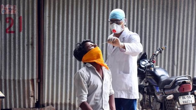 A health worker takes a swab sample from a man for coronavirus testing, near Bal Bhawan ITO in New Delhi.(Raj K Raj/HT PHOTO)