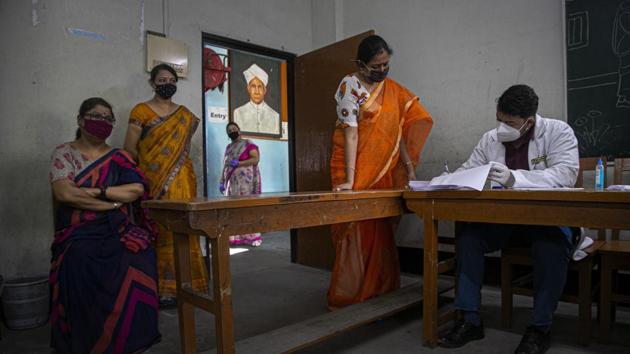 An Indian doctor collects details as a health worker collects nasal swab samples of teachers to test for Covid-19 at a school before classes open in Guwahati. (AP) An Indian doctor collects details as a health worker collects nasal swab samples of teachers to test for Covid-19 at a school before classes open in Guwahati. (AP)