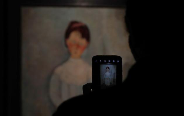 A journalist takes a photos with his mobile phone of a painting by Amedeo Modigliani during the "5" or The Paris of Modigliani and his contemporaries exhibit at the Palacio de Bellas Artes in Mexico City, Monday, Sept. 7, 2020. (AP) A journalist takes a photos with his mobile phone of a painting by Amedeo Modigliani during the "5" or The Paris of Modigliani and his contemporaries exhibit at the Palacio de Bellas Artes in Mexico City, Monday, Sept. 7, 2020. (AP)
