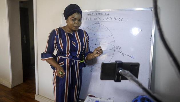 Mathematics teacher Basirat Olamide Ajayi, 36, teaches longitude and latitude online via her mobile phone from her house in Lagos, Nigeria.(AP)
