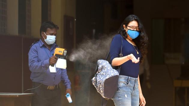 College staff sanitize a student before entering the exam center (Satish Bate/HT Photo) College staff sanitize a student before entering the exam center (Satish Bate/HT Photo)