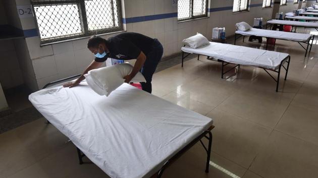 A worker makes a bed at newly built Covid-19 isolation ward in Balak Ram Hospital, Timarpur, New Delhi.(Sanchit Khanna/HT PHOTO)