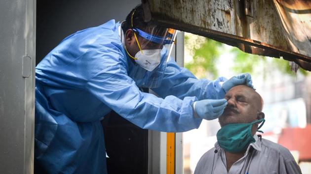 A health worker in PPE coveralls collects a swab sample from a man to test for Covid-19 at Hari Nagar in New Delhi.(Sanchit Khanna/HT PHOTO) A health worker in PPE coveralls collects a swab sample from a man to test for Covid-19 at Hari Nagar in New Delhi.(Sanchit Khanna/HT PHOTO)