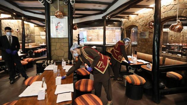 Employees wearing protective masks and face shields clean inside the Bukhara Restaurant at the ITC Maurya Sheraton Hotel in Delhi.(Bloomberg) Employees wearing protective masks and face shields clean inside the Bukhara Restaurant at the ITC Maurya Sheraton Hotel in Delhi.(Bloomberg)