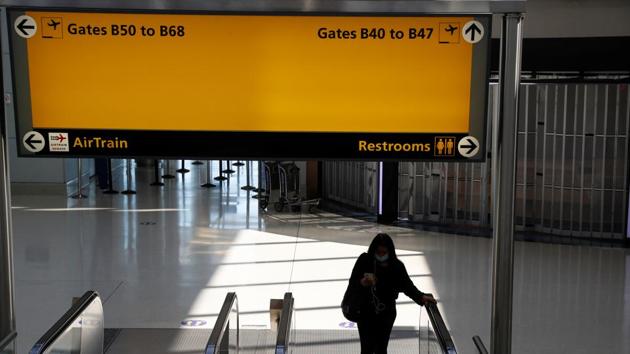 A woman wearing a protective face mask walks down an escalator amid the coronavirus disease pandemic, at Newark Liberty International Airport in Newark, New Jersey, US on September 8.(REUTERS)