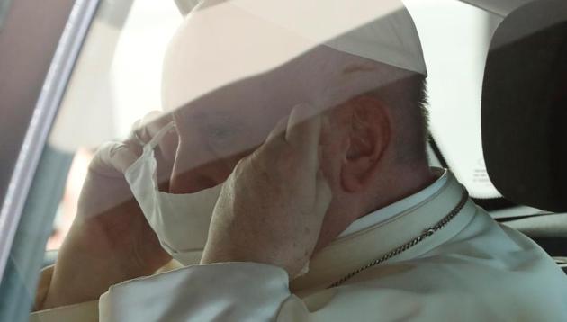 Pope Francis puts on a protective face mask as he enters the car after holding the weekly general audience, at the Vatican (REUTERS)
