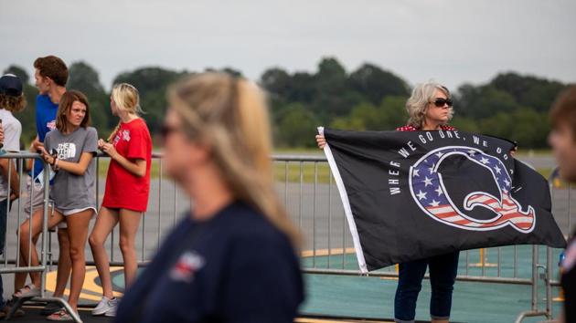 An attendee holds a QAnon flag before a campaign rally for U.S. President Donald Trump in Winston-Salem, North Carolina, US (Bloomberg) An attendee holds a QAnon flag before a campaign rally for U.S. President Donald Trump in Winston-Salem, North Carolina, US (Bloomberg)