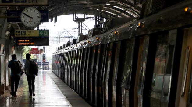 Passengers walk past a Delhi Metro Rail Corp. train sitting at a station platform during the resumption of services in New Delhi.(Bloomberg)