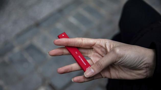 A woman holds a Puff Bar flavored disposable vape device in New York.(AP)