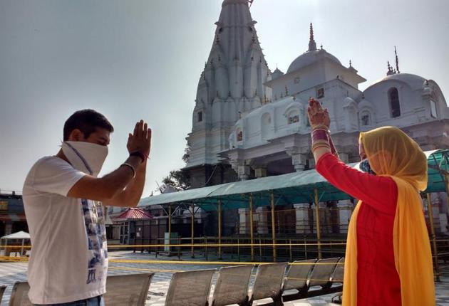 A couple offering prayers at the Brajeshwari Temple in Kangra on Thursday morning. Temples in Una, Bilaspur and Hamirpur districts were also opened after five months.(HT Photo)