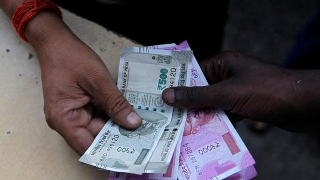 A customer hands Indian currency notes to an attendant at a fuel station in Mumbai, India, August 13, 2018. REUTERS/Francis Mascarenhas/Files(REUTERS)