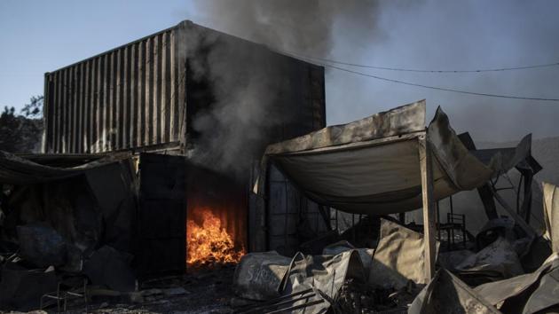 New, small fires sprang up in the remains of tents set up outside the camp, fanned by strong winds on September 10 morning. Authorities say the original fire in the camp on the island of Lesbos was deliberately started September 8 evening by residents angered by quarantine measures imposed to contain a Covid-19 outbreak after 35 people tested positive. (Petros Giannakouris / AP) New, small fires sprang up in the remains of tents set up outside the camp, fanned by strong winds on September 10 morning. Authorities say the original fire in the camp on the island of Lesbos was deliberately started September 8 evening by residents angered by quarantine measures imposed to contain a Covid-19 outbreak after 35 people tested positive. (Petros Giannakouris / AP)