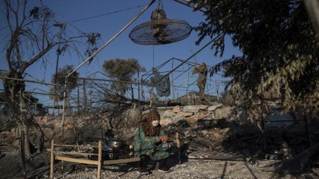 A migrant woman sitting in the Moria refugee camp on the island of Lesbos in Greece on September 10. A second fire in Greece's largest Moria refugee camp has destroyed nearly everything that had been spared in a blaze two days prior, Greece's migration ministry said on September 10, leaving thousands more people in need of emergency housing. (Petros Giannakouris / AP) A migrant woman sitting in the Moria refugee camp on the island of Lesbos in Greece on September 10. A second fire in Greece's largest Moria refugee camp has destroyed nearly everything that had been spared in a blaze two days prior, Greece's migration ministry said on September 10, leaving thousands more people in need of emergency housing. (Petros Giannakouris / AP)