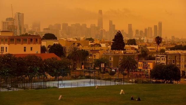 Visitors seen sitting under the orange sky at Dolores Park in San Francisco on September 9. Borrmann said the conditions were expected to linger until September 11. By then, the district expects to issue its 25th consecutive ‘Spare The Air’ alert requiring residents to cut pollution — the longest stretch since the program began in 1991. (Brittany Hosea-Small / AFP)