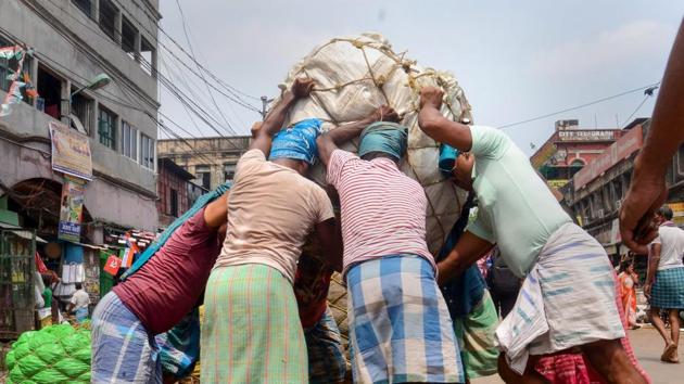 In this file picture, workers prepare to carry a basket on their heads at a wholesale market, in Kolkata. Within South Asia, it forecast that India’s ratio of general government (GG) debt-to-GDP will stabilise in the fiscal year ending March 2022 at just above 85 per cent. (PTI) In this file picture, workers prepare to carry a basket on their heads at a wholesale market, in Kolkata. Within South Asia, it forecast that India’s ratio of general government (GG) debt-to-GDP will stabilise in the fiscal year ending March 2022 at just above 85 per cent. (PTI)