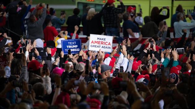 Attendees hold signs during a campaign rally with U.S. President Donald Trump in Freeland, Michigan, US (Bloomberg) Attendees hold signs during a campaign rally with U.S. President Donald Trump in Freeland, Michigan, US (Bloomberg)