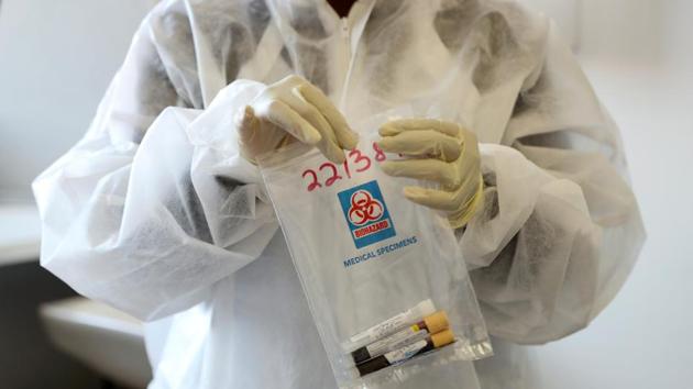 A health worker holds a COVID-19 sample collection kit of a vaccine trials' volunteer, after they were tested for the coronavirus disease and take part in the country's human clinical trial for potential vaccines at the Wits RHI Shandukani Research Centre in Johannesburg, South Africa. (REUTERS) A health worker holds a COVID-19 sample collection kit of a vaccine trials' volunteer, after they were tested for the coronavirus disease and take part in the country's human clinical trial for potential vaccines at the Wits RHI Shandukani Research Centre in Johannesburg, South Africa. (REUTERS)