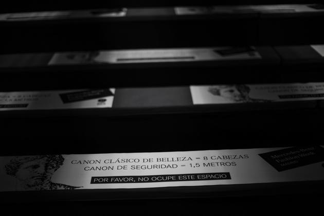Stickers marking social distance are placed on spectators benches of the Mercedes-Benz Fashion Week in Madrid, Spain, Wednesday, Sept. 9, 2020.  The text reads in Spanish "Classic canon of beauty = 8 heads. Safety canon = 1.5 meters . Please do not occupy this space". (AP) 