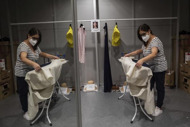 A staffer of Spanish designer Devota and Lomba works at the backstage a day before the start of the Mercedes-Benz Fashion Week in Madrid, Spain, Wednesday, Sept. 9, 2020.  (AP) 