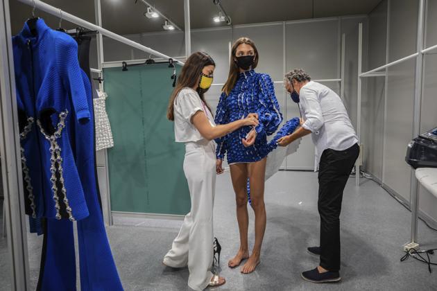 Spanish designer Marcos Luengo, right, works at the backstage a day before the start of the Mercedes-Benz Fashion Week in Madrid, Spain, Wednesday, Sept. 9, 2020.  (AP) 