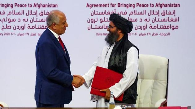 Mullah Abdul Ghani Baradar, the leader of the Taliban delegation, and Zalmay Khalilzad, US envoy for peace in Afghanistan, shake hands after signing an agreement at a ceremony between members of Afghanistan's Taliban and the US in Doha, Qatar.(REUTERS)