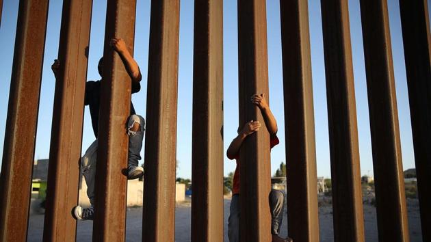 In this file photo taken on June 24, 2018 children climb up the Mexican side of the US-Mexico border fence in Sunland Park, New Mexico. (AFP)