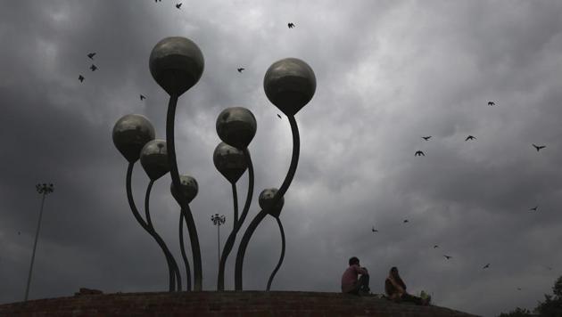 A laborer couple takes rest next to a sculpture as the sky fills up with heavy monsoon rain clouds in New Delhi. (AP) A laborer couple takes rest next to a sculpture as the sky fills up with heavy monsoon rain clouds in New Delhi. (AP)