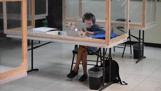 A student follows along remotely with their regular school teacher's online live lesson from a desk separated from others by plastic barriers at STAR Eco Station Tutoring & Enrichment Center on September 10, in Culver City, California. A lawsuit brought by the Orange County Board of Education seeking to compel the state of California to reopen public schools was shot down by the California Supreme Court on September 10. (Robyn Beck / AFP) A student follows along remotely with their regular school teacher's online live lesson from a desk separated from others by plastic barriers at STAR Eco Station Tutoring & Enrichment Center on September 10, in Culver City, California. A lawsuit brought by the Orange County Board of Education seeking to compel the state of California to reopen public schools was shot down by the California Supreme Court on September 10. (Robyn Beck / AFP)